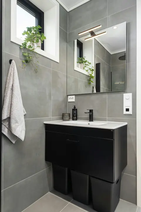 A bathroom sink under a mirror with soft ambient lighting