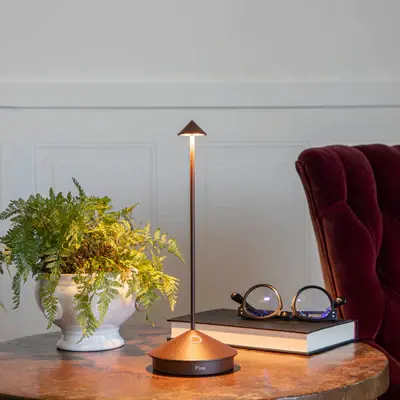 Cordless floor lamp beside modern armchairs in a minimalist living room