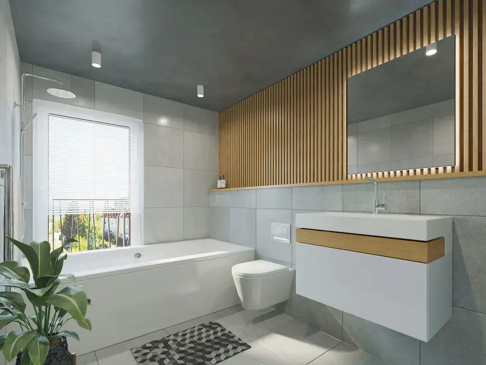 Minimalist bathroom with white pedestal sink, toilet, and bathtub under natural light