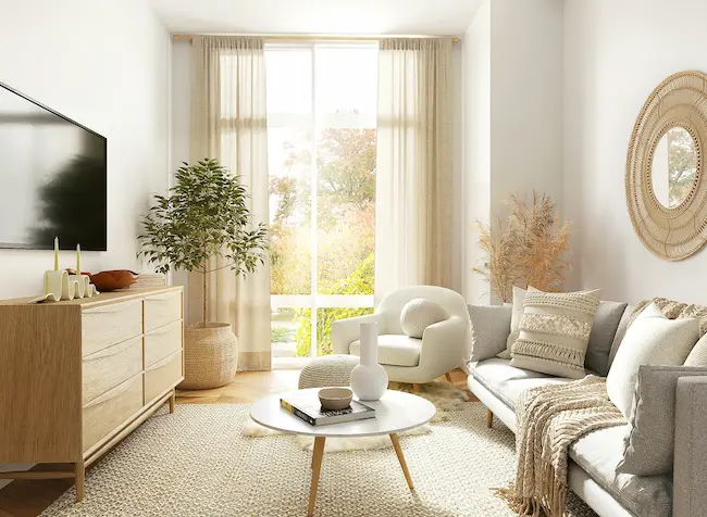 Bright living room with ivory sectional sofa, round wood coffee table, and neutral wall art.
