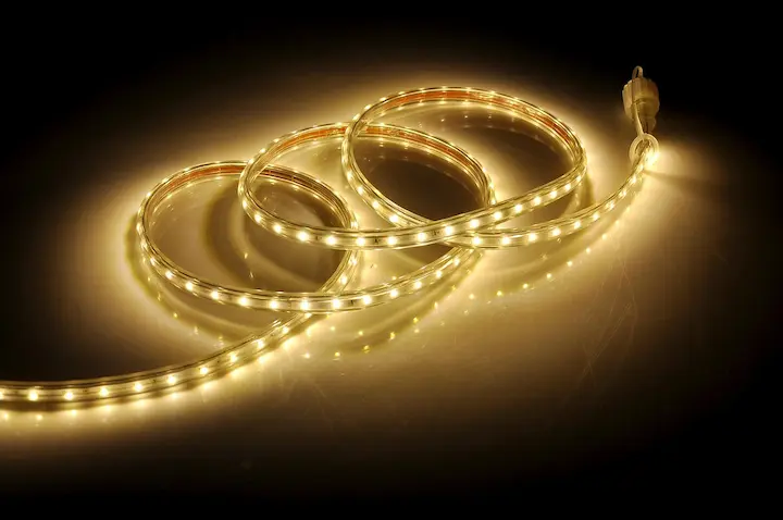 Glowing flexible LED strip lights coiled on a surface.