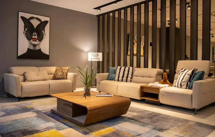 Neutral-toned living room with two modern couches, a wood coffee table, and warm lighting.