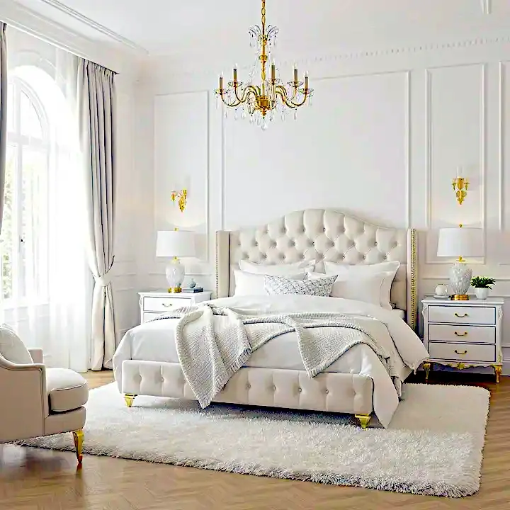 Standard UK bedroom with white tufted upholstered bed, matching nightstands, gold wall sconces, and plush white area rug